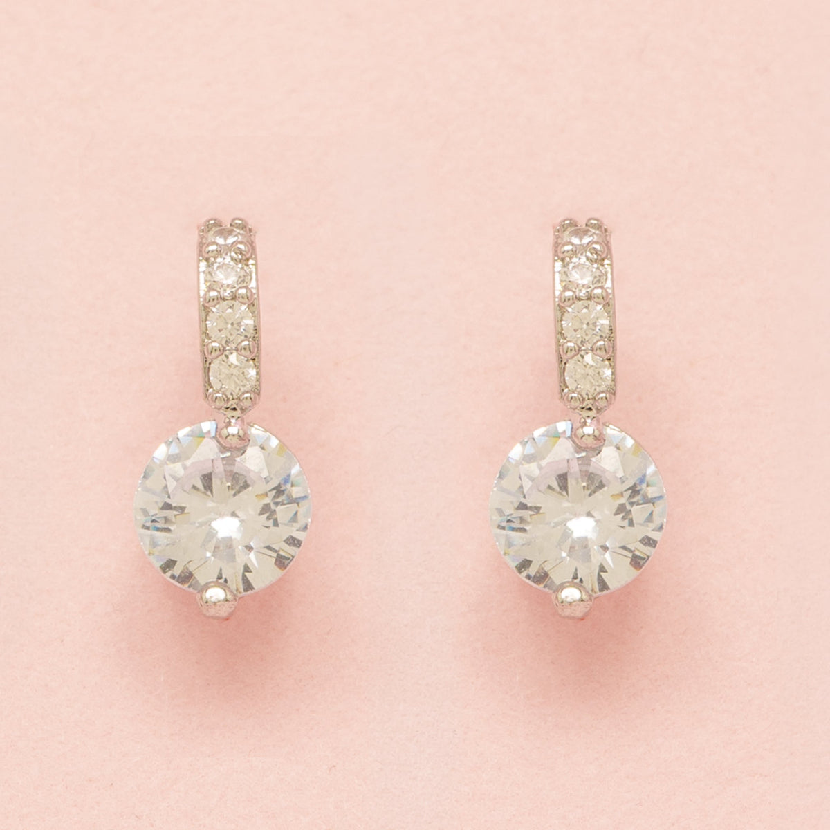 Elegant Wishes silver crystal earrings on a pink background