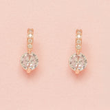Elegant Wishes rose gold crystal earrings on a pink background