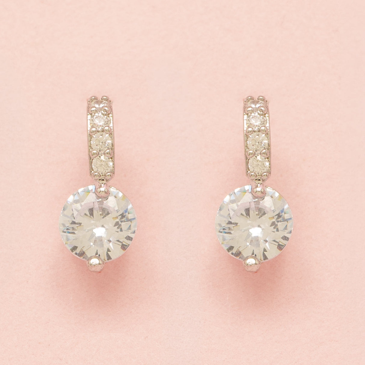 Elegant Wishes silver crystal earrings on a pink background
