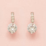 Elegant Wishes silver crystal earrings on a pink background