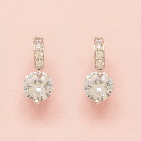Elegant Wishes silver crystal earrings on a pink background